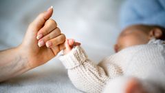 Madre agarrando la mano de un beb.