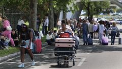 Pasajeros caminan con sus equipajes en el exterior del aeropuerto de Lisboa